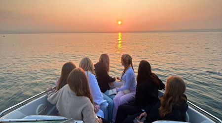 Studenti in barca che guardano il tramonto durante il loro secondo semestre all'estero