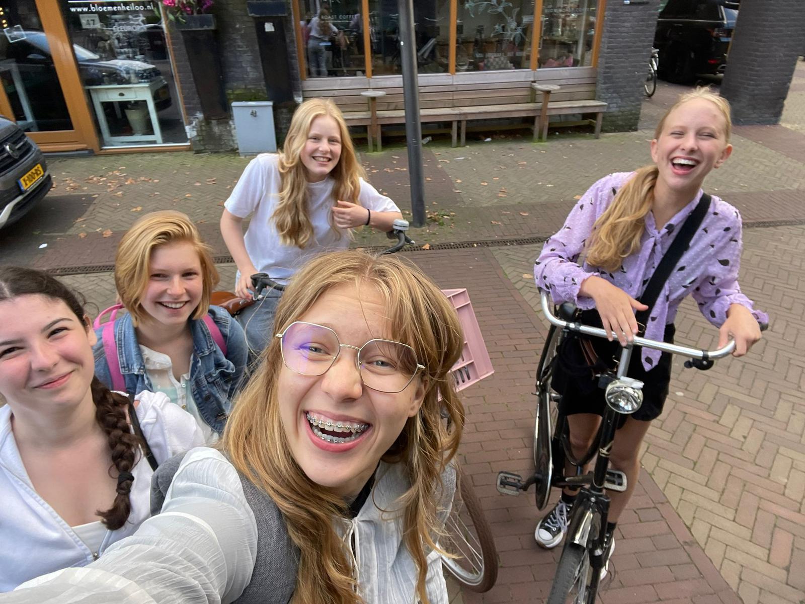 Ragazze adolescenti sorridenti in bicicletta durante le attività pomeridiane del corso di lingua all'estero